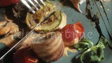 特写镜头：鸡肉在咸肉中与蔬菜一起烤，在蓝色盘子上配上酱汁和绿色沙拉